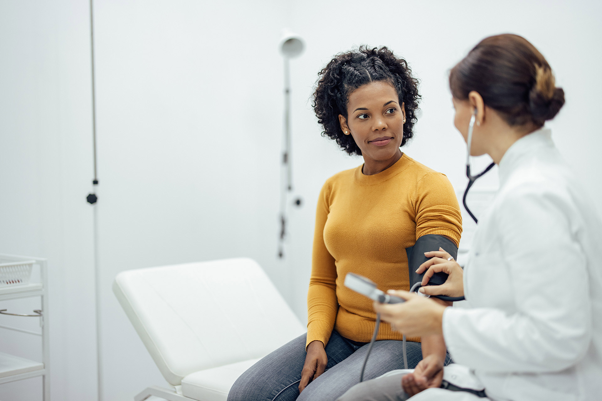 a patient having blood pressure checked in a medical exam room