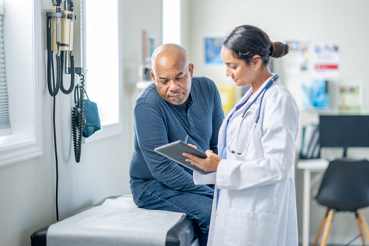 Two people in a medical exam room looking at a tablet