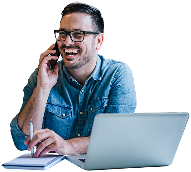 Man talking on phone laughing while at computer
