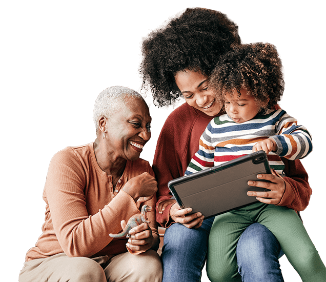 Family smiling while looking at computer tablet