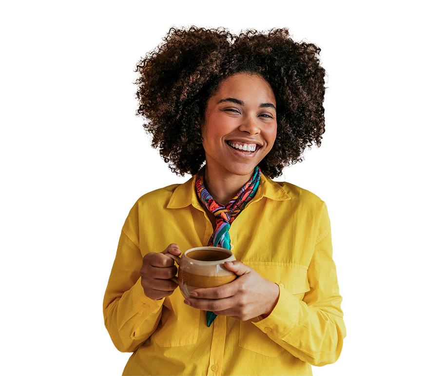 ny-small-group A woman with curly hair smiles while holding a coffee cup in her hands.
