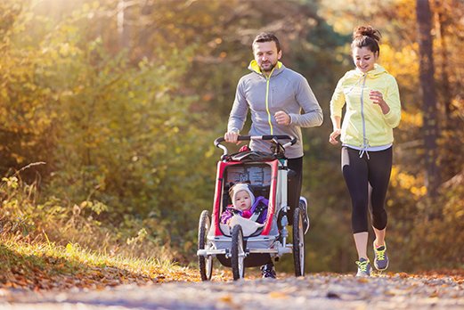 Man and woman running with child in stroller