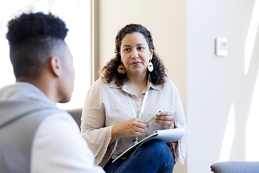 Woman taking notes listening to man in office setting