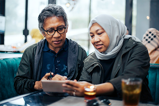 Man and woman sitting looking at smartphone