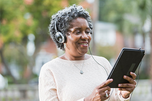 1633188-4TruHearing-521x348 Woman smiling listening to tablet computer
