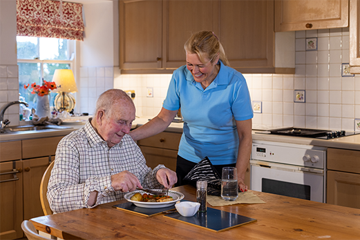 1633188-5Moms-Meals-521x348 Man eating dinner in kitchen with woman smiling