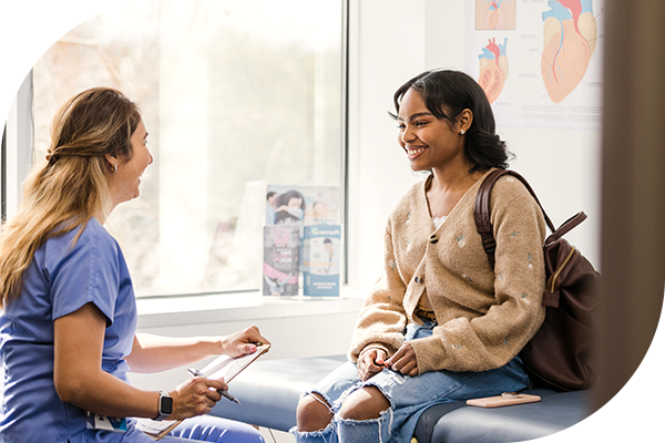 Una mujer joven conversa con su profesional de la salud.