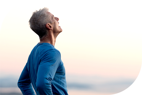 Person outdoors taking a deep breath as part of healthy breathing and COPD management.