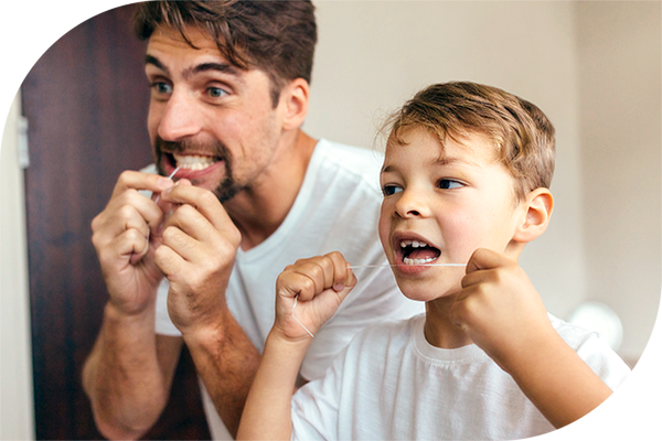 A father and son floss their teeth together
