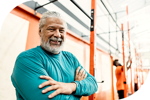 Bearded man with his arms crossed, at the gym.