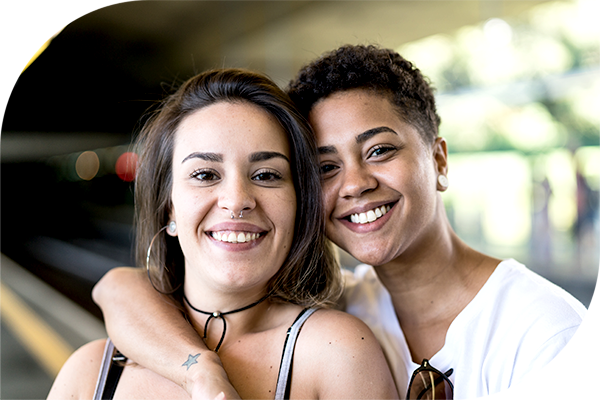 Two people posing together with one person’s arm around the other.