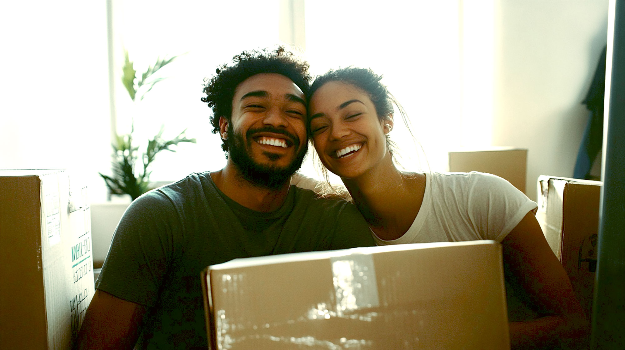 a young couple indoors surrounded by boxes