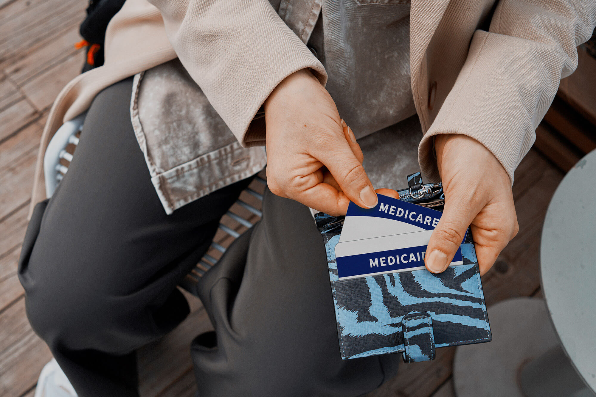 a man holding a wallet with a medicaid and medicare card