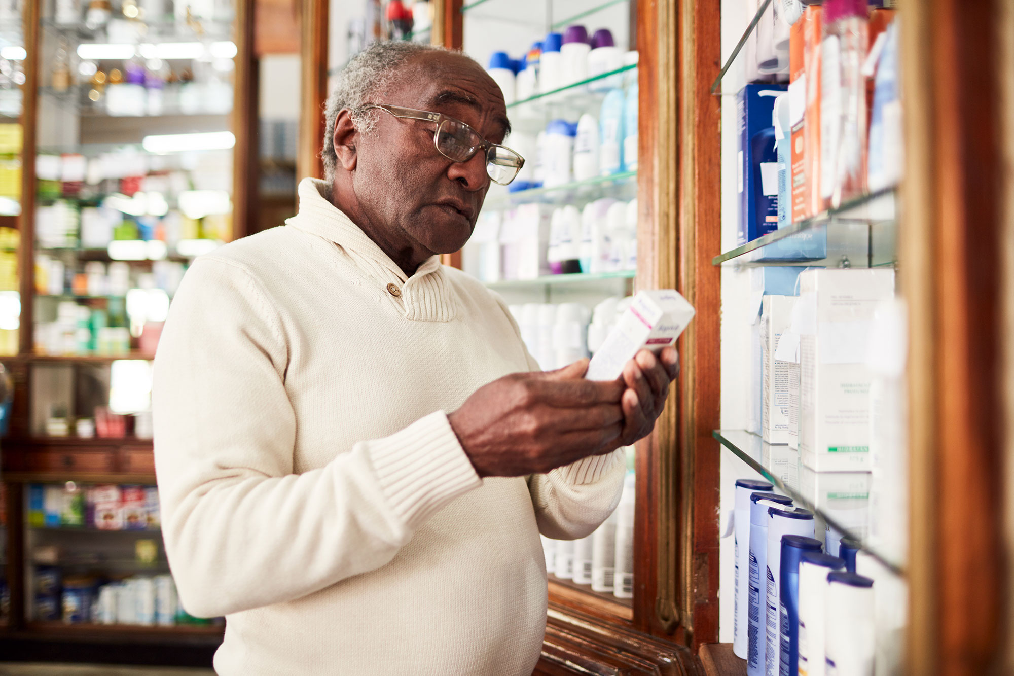 older man reading a medicine label