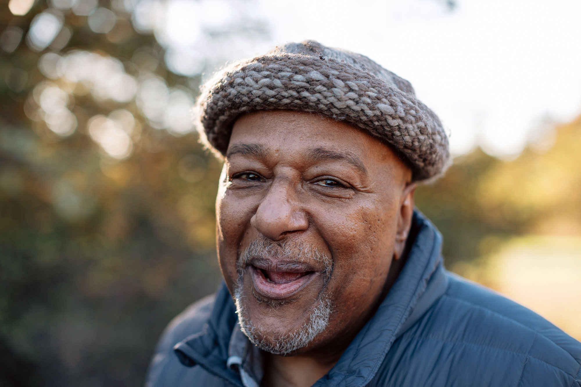 older man smiling outside