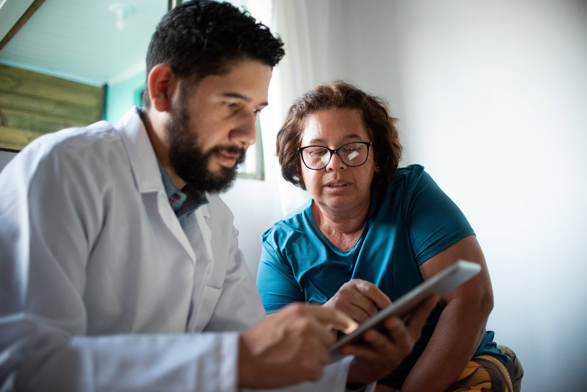 a doctor and woman patient looking at a tablet