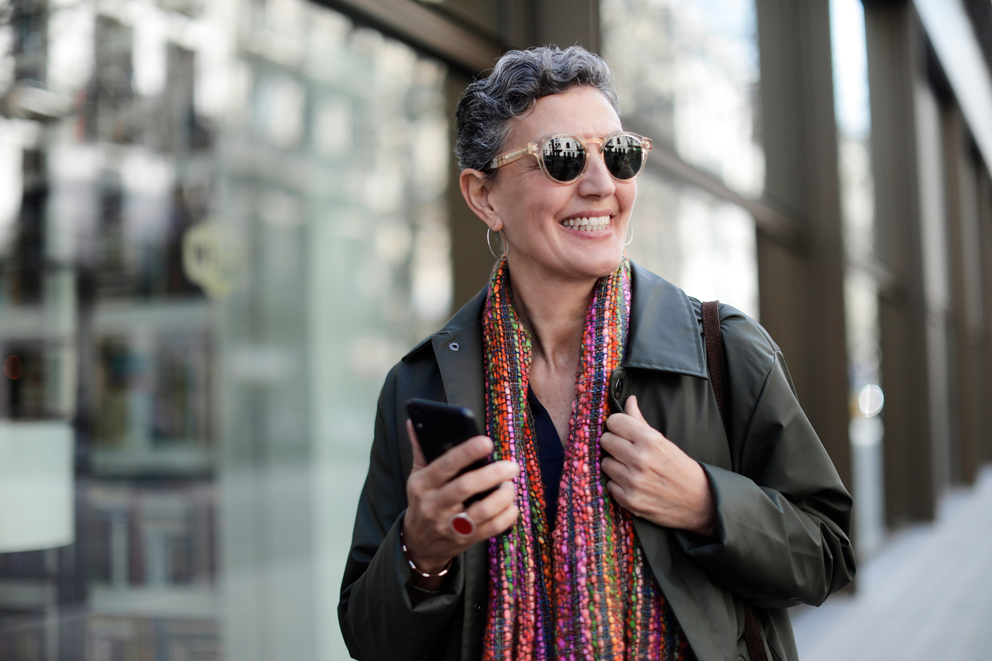 a smiling woman with glasses and a scarf