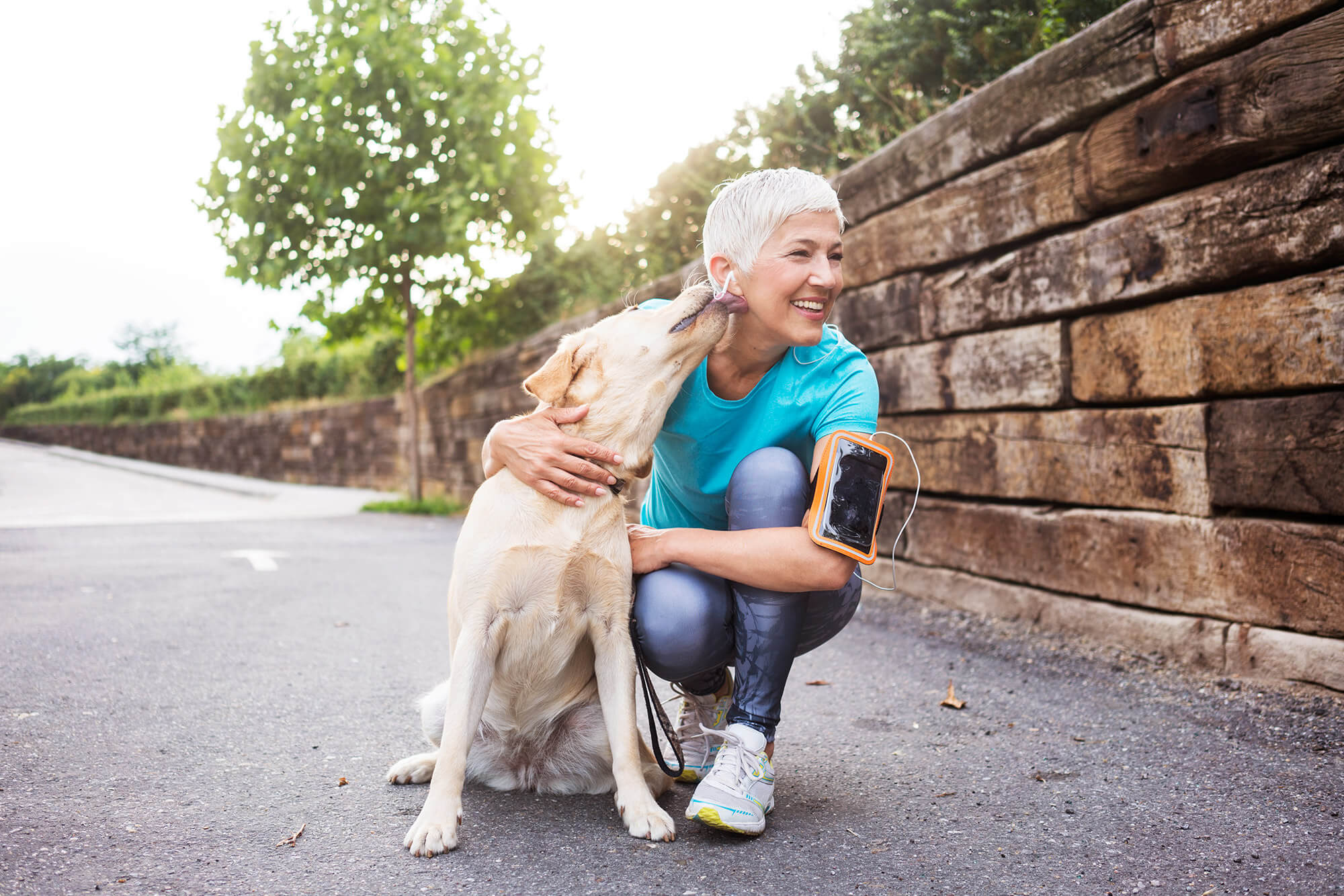 a woman kneels beside her dog