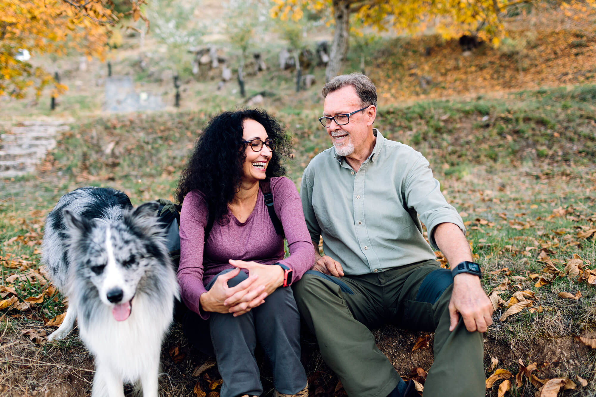 couple sitting outdoors with a dog