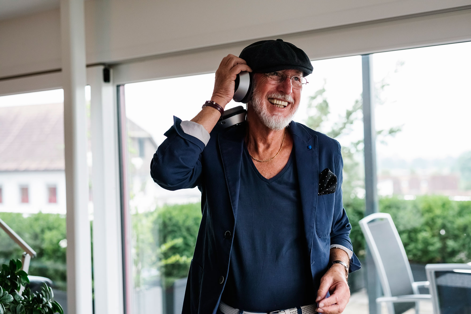 older man with a hat listening to music through headphones