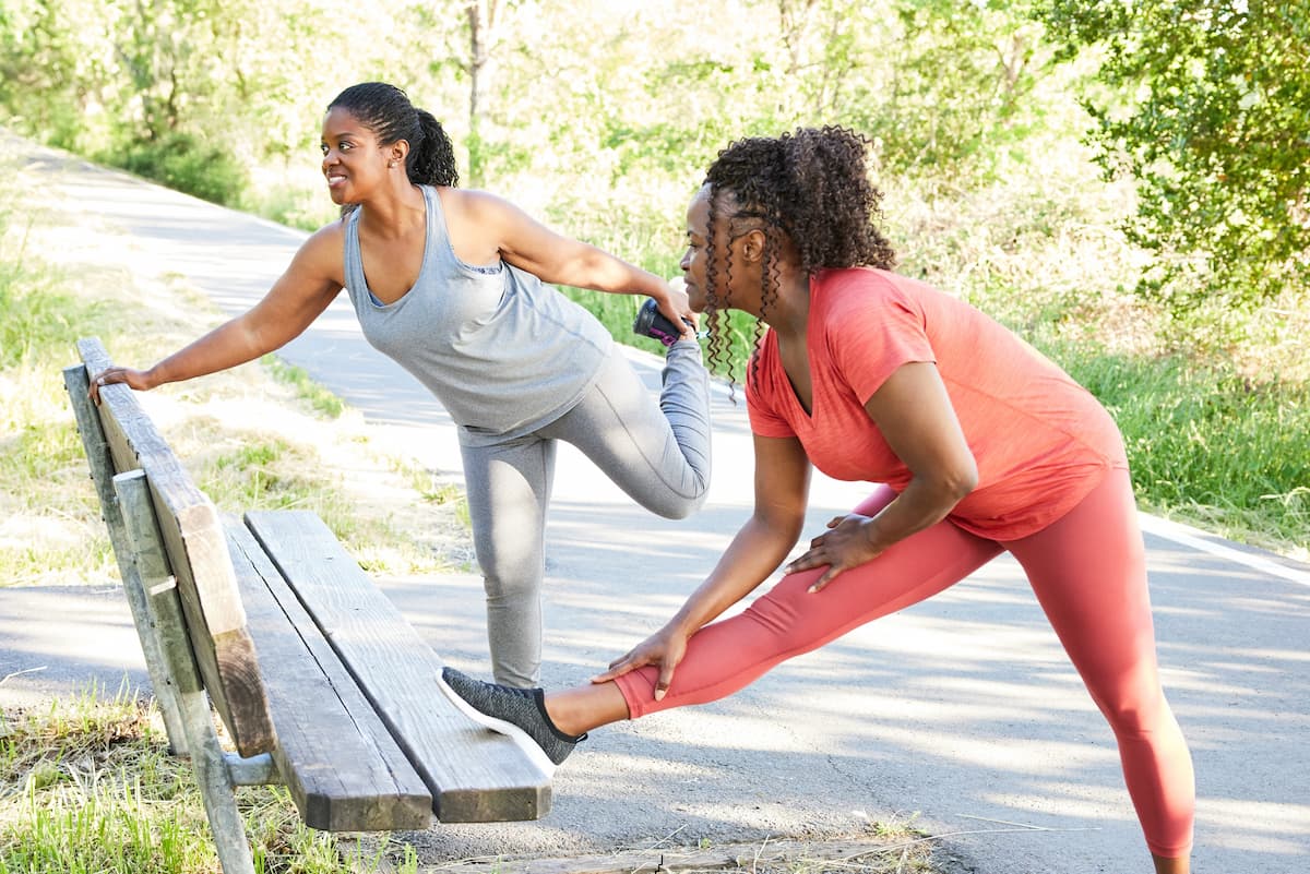 two women stretching in park