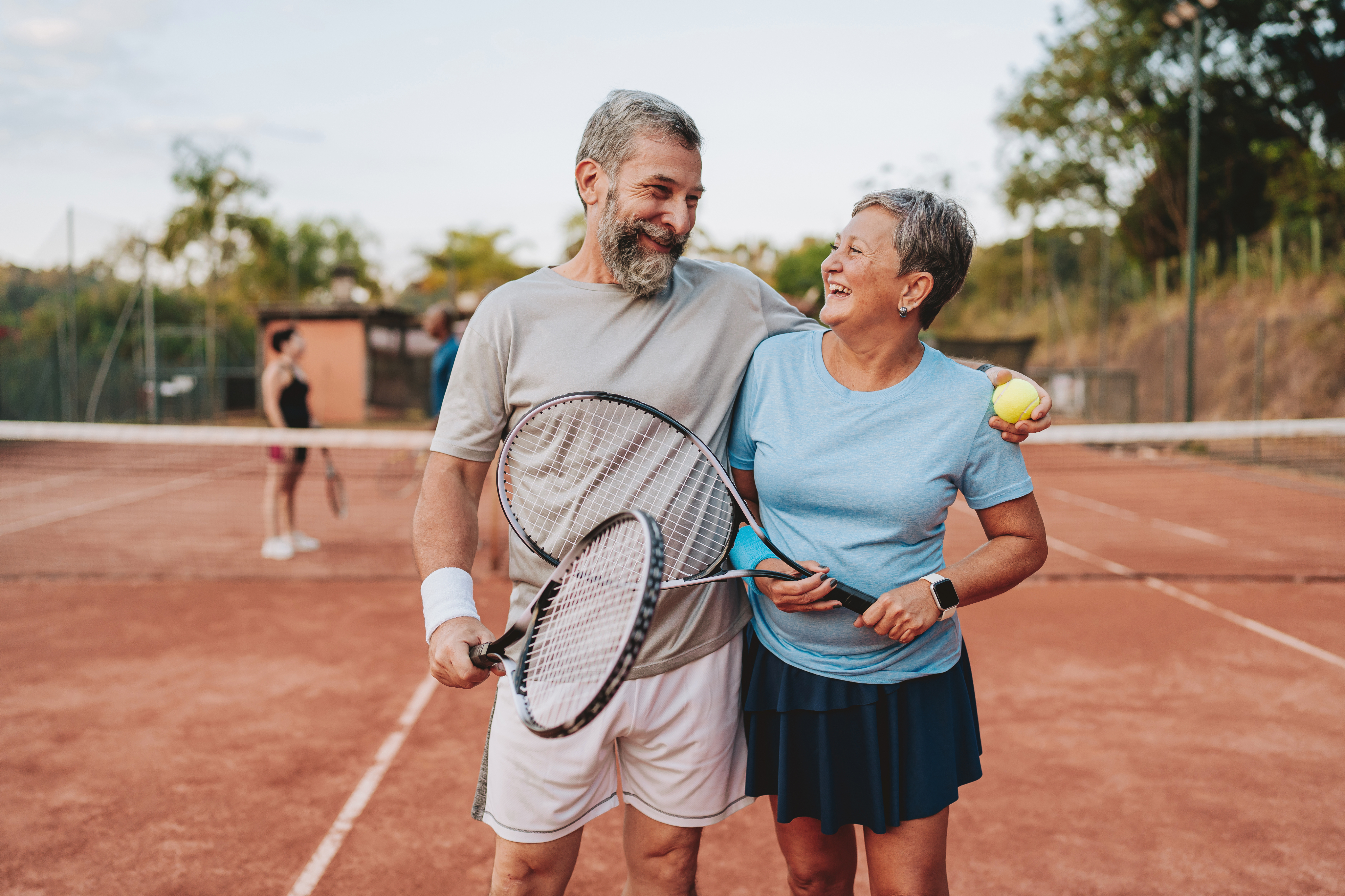 eldery couple playing tennis after attending a medicare seminar