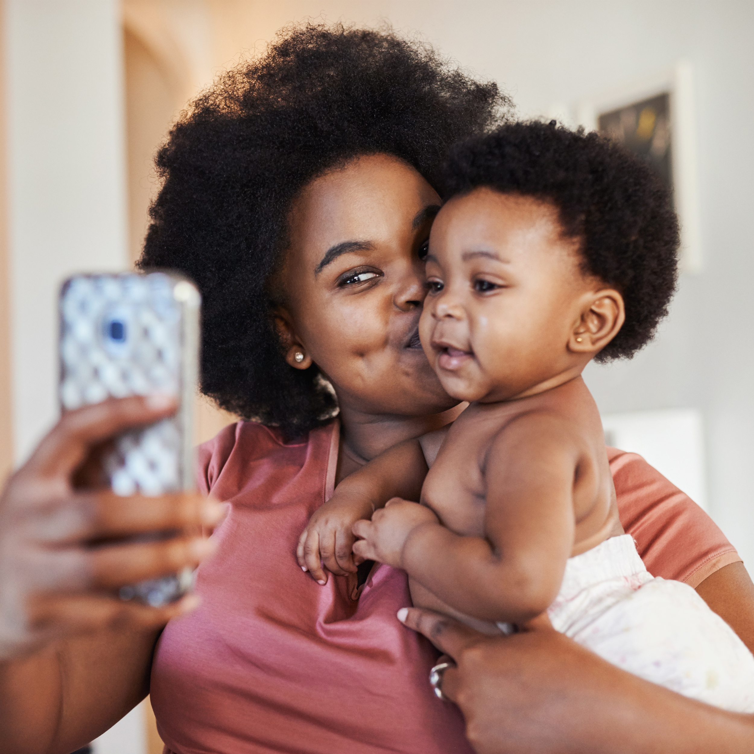 woman holding a baby while taking a selfie