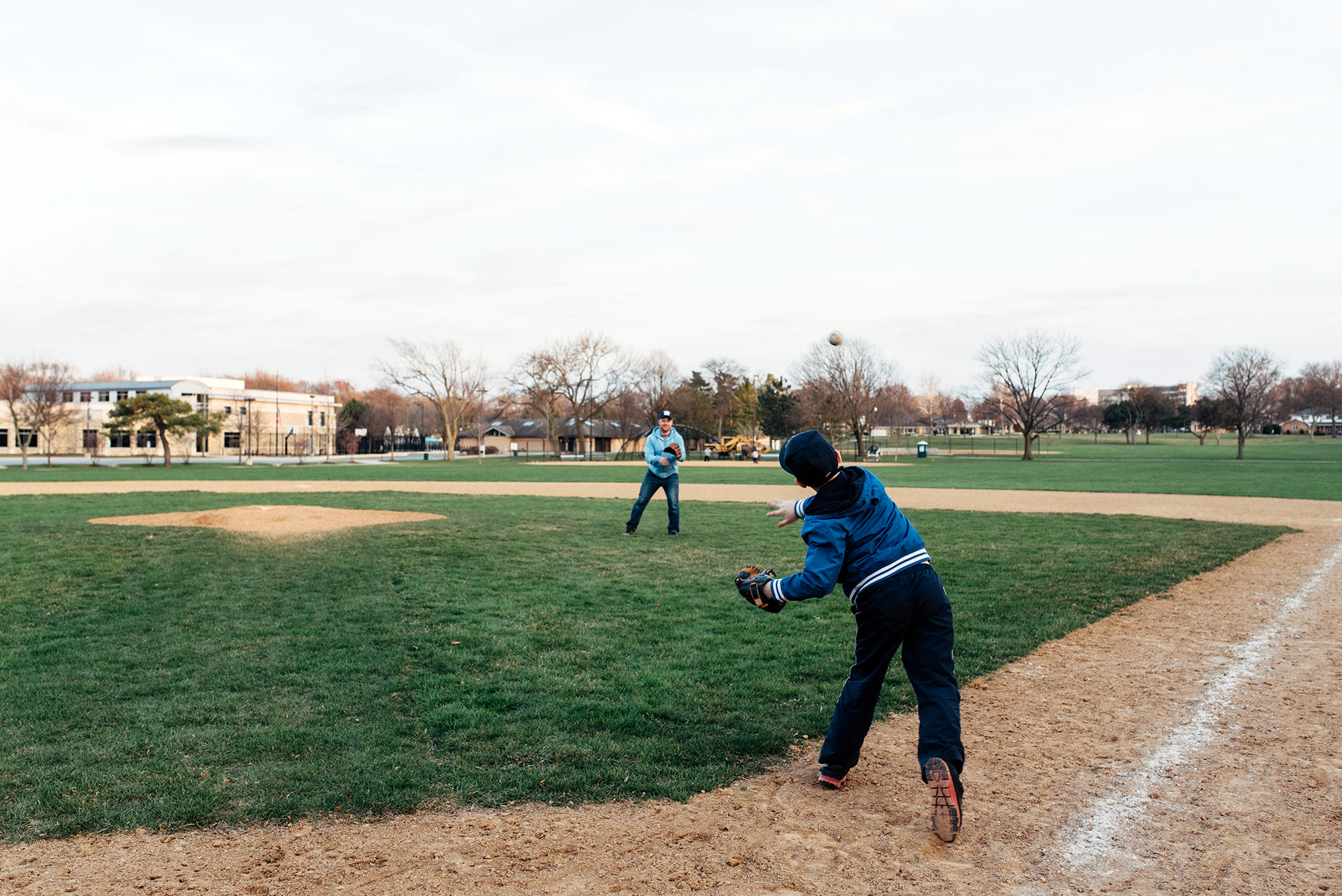 father and son playing baseball together outdoors