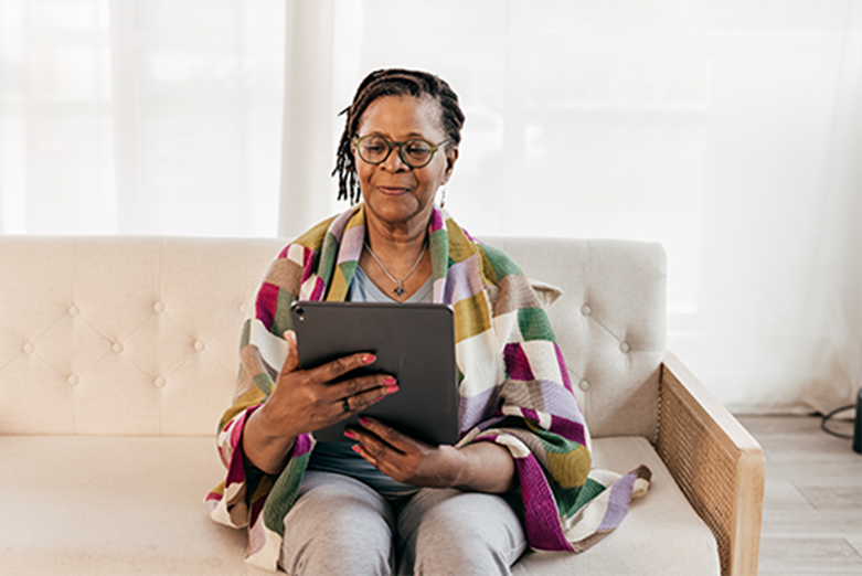 woman-sitting-on-couch-reading-tablet woman sitting on couch reading tablet
