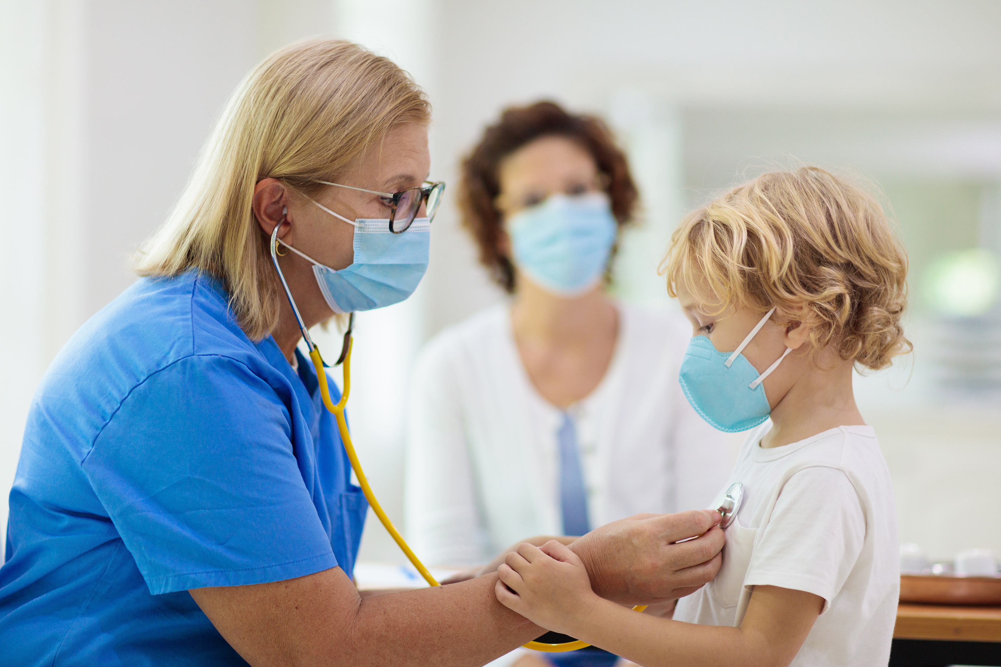 doctor-examining-sick-child-in-face-mask doctor examining sick child in face mask