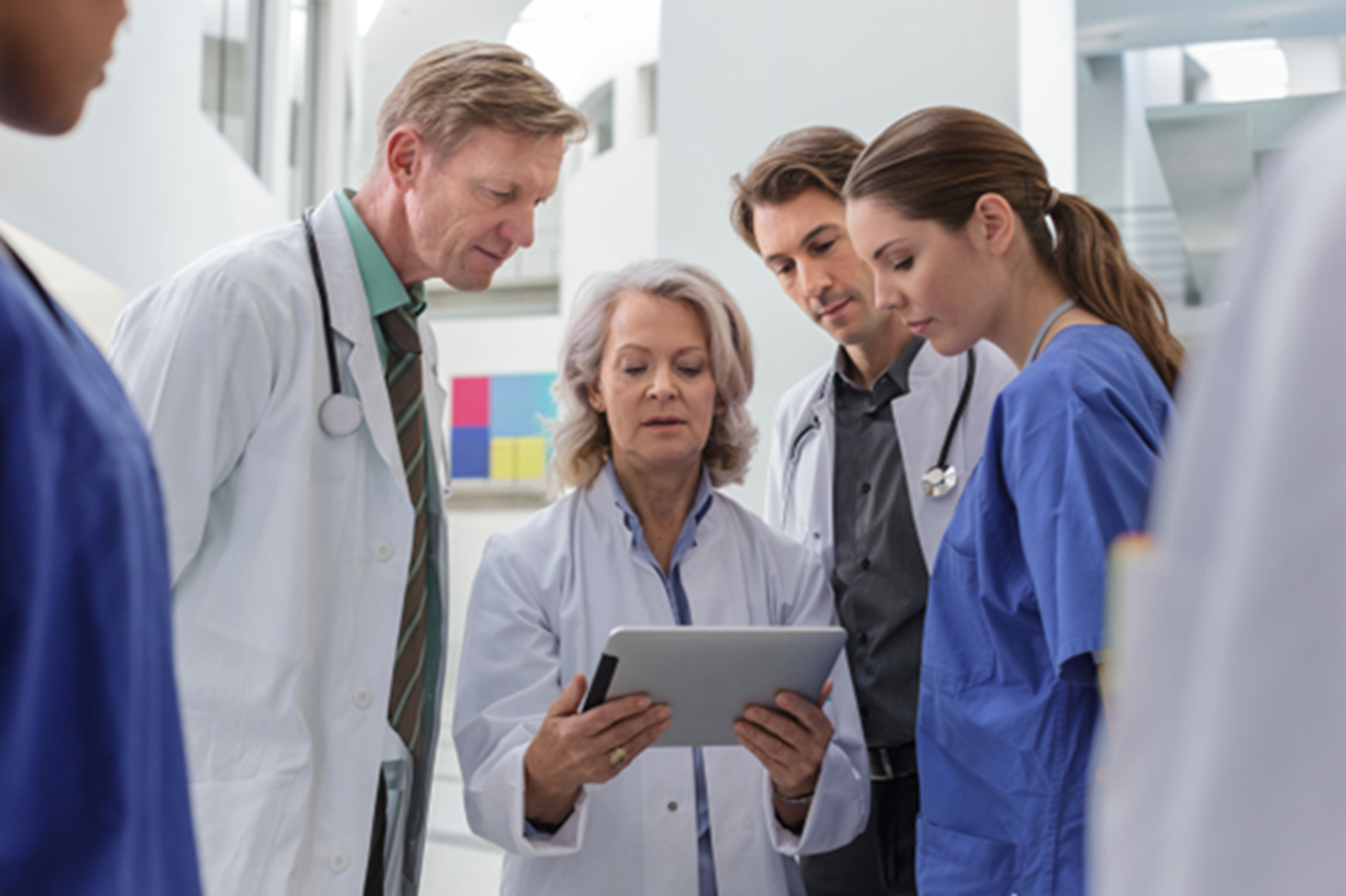 doctors and nurses huddled around a tablet