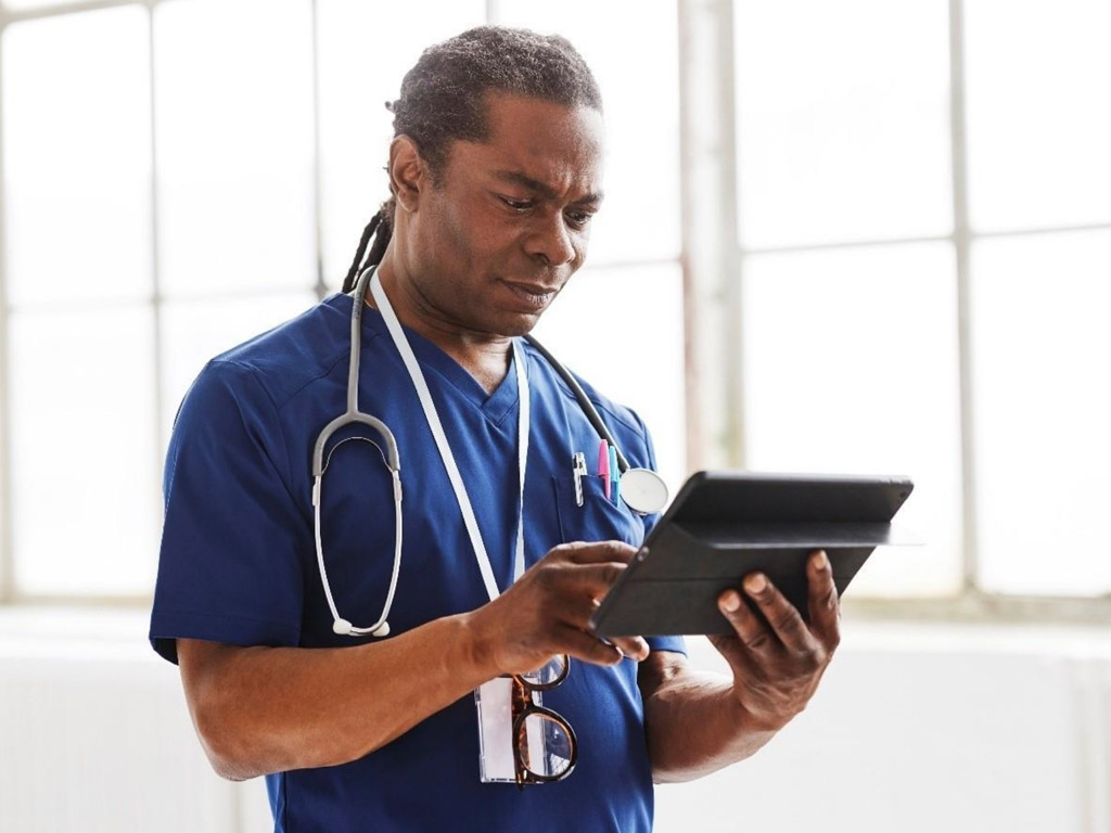 a male doctor in scrubs using a tablet