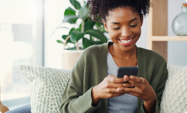 MicrosoftTeams-image 1 a woman sitting on a couch looking at a phone