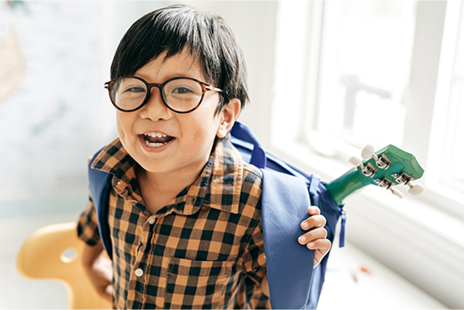 a small boy with glasses and wearing a backpack